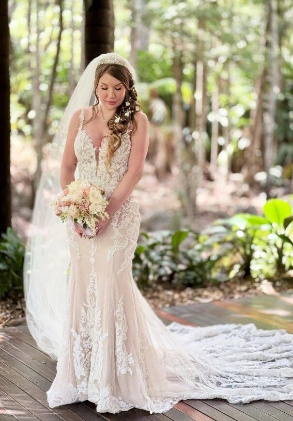 Bride in full lace gown and veil, outdoor forest setting