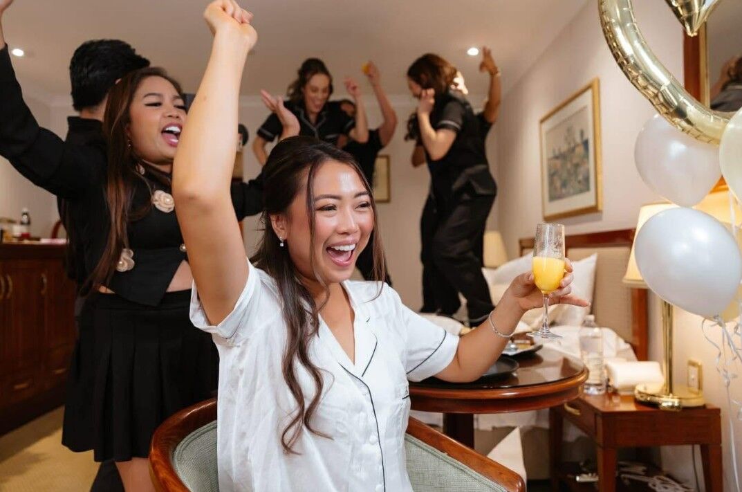 Bridal party celebrating together while getting ready, candid moment